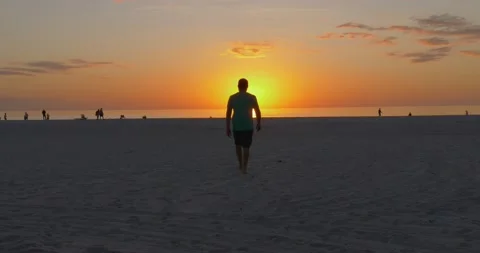 492 Man on the beach walking into the sunset Stock-Footage 134547704