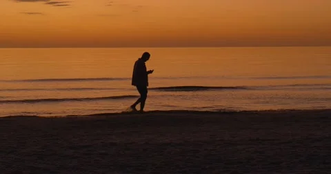 494 Man walking on the shore of the beach during the sunset Stock-Footage 134547656