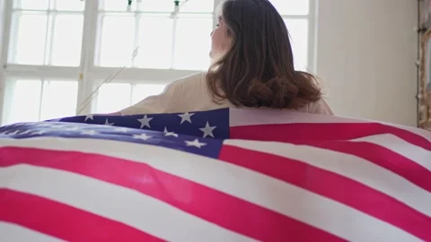 4k 10 bit. The American flag beautifully waving behind a woman walking into the Stock Footage 152906499