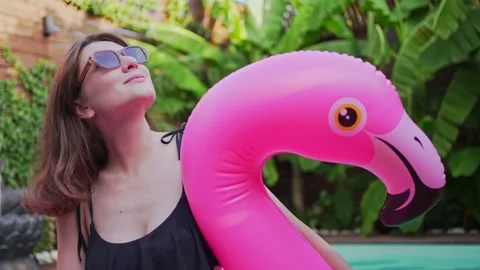 4K 10 bit. Model poses on inflatable mattress of pink color. Relax in sunglasses Stock Footage 161885746