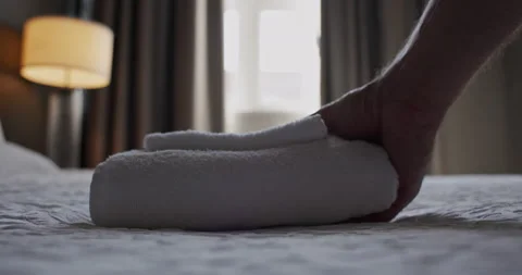 4K 120 fps (23.98) Close up of hand removing fresh towels from hotel room bed Stock Footage 219357969