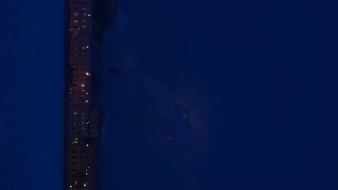 4K 16:9 winter night cityscape. Giant full in clouds Stock Footage 168976940