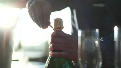 4K 25 fps slowmotion unwrapping champagne bottle close up sunset Stock Footage 171209927