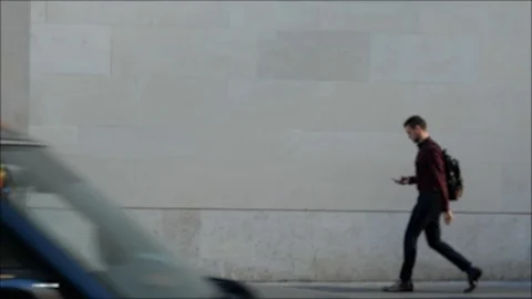 4k 25fps men with backpacks walking along tall wall Stock Footage 120171289