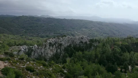 4K 50FPS Smooth flight of a drone over a rock among a green forest Vídeos de archivo 169031620