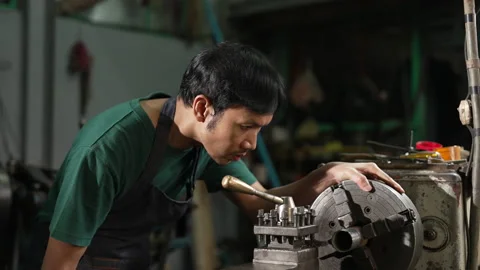 4K 50fps, A young man in a small family-owned factory, is using a lathe, 스톡 동영상 192331534