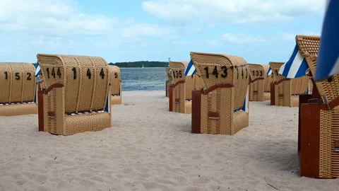 4K 60 fps video of beach chairs on white sand beach during windy weather ot B Stock Footage 155703188