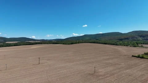 4K 60fps Drone Flyover: Arable Agricultural Field and Mountains Stockbeeldmateriaal 343247842