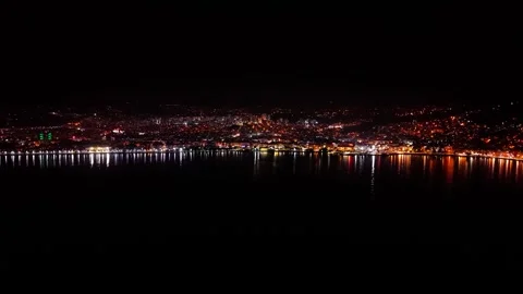 4K 60FPS Drone Pullback From Coastal City Over Sea at Night Video stock 334305282
