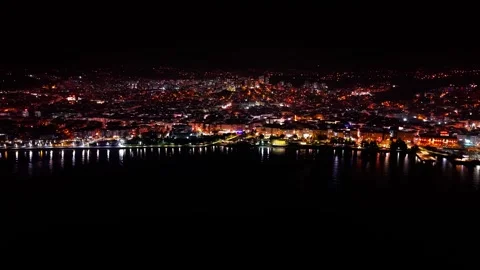 4K 60FPS Drone Pullback From Coastal City Over Sea at Night Stock Footage 334305324