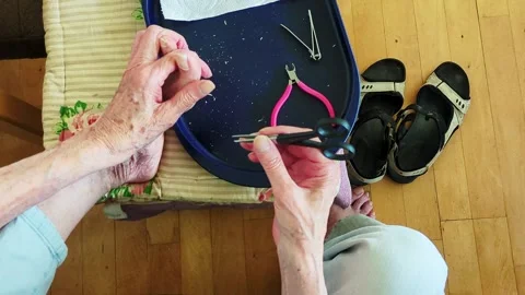 4K 60FPS Overhead View: Senior Trimming Toenails at Home Vidéo 336098120