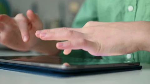 4K 60fps video of child tapping tablet doing homework at online course Stock Footage 168860660