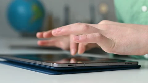 4K 60fps video of child tapping tablet doing homework at online course Stock Footage 168862020