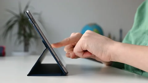 4K 60fps video of child tapping tablet doing homework at online course Stock Footage 168862767