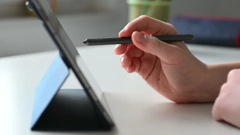 4K 60fps video of child tapping tablet doing homework at online course Stock Footage 168863287