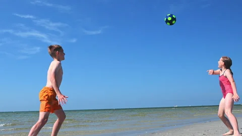 4K 60fps video of two happy  children playing volleyball on beach Video stock 156924893