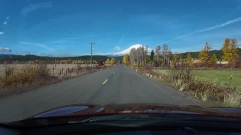 4K action camera footage driving toward snow-covered Mount Adams on rural road 스톡 동영상 320471818