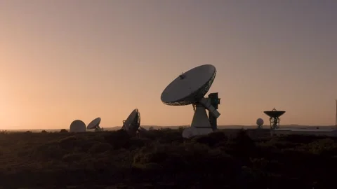4K aerial approaching a large satellite dish at sunset Stock Footage 283584919