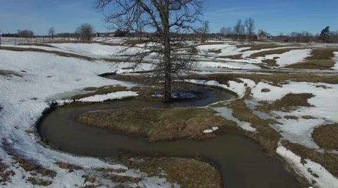 4k aerial ascend with tree in middle of winding stream Stock Footage 61377177
