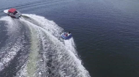 4k aerial boat almost ejects tuber over wave Stock Footage 64984767