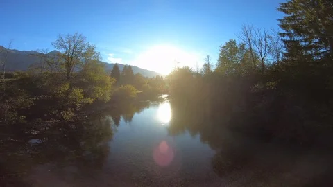 4K AERIAL Down the river stream as the sun is setting behind the mountains Stock Footage 117928192