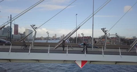 4k Aerial dramatic shot of a black girl throwing drugs off Erasmusbrug bridge Stock Footage 89783550