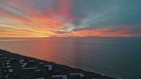 4K aerial, dramatic sky, sunrise over sea &amp; town, frost, cold Winter morning, UK Stock Footage 230718400