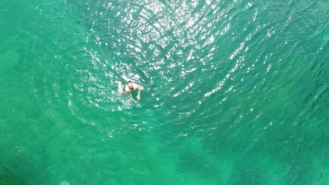 4k aerial drone flight over turquoise lake with swimmer and friends Video stock 80454167