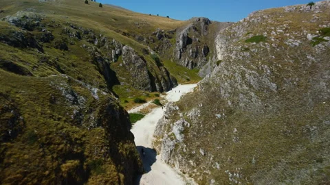 4K aerial drone flight through white canyon with yellow grass and walking people Stock Footage 315191670
