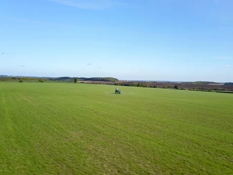 4k aerial drone footage circling moving tractor spraying crops pesticide Stock Footage