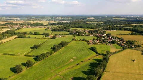 4K aerial drone footage towards village in countryside rural England UK Stock Footage