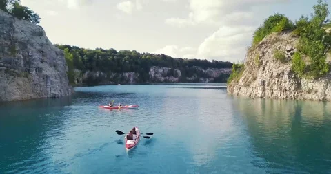 4k Aerial Drone Moving Forward, Passing Through Kayaks at a Blue Lake Vídeo Stock 95966871