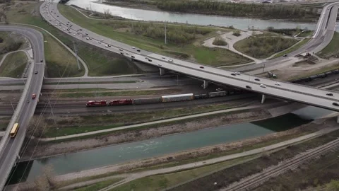 4K Aerial Drone Pullback of Freight Train Under Deerfoot Trail Highway Видео 337088274