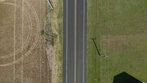 4k Aerial Drone road in between farm and grass overhead Stock Footage 196893918
