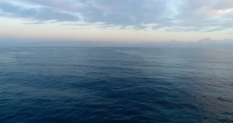 4k aerial drone shot flying over the ocean at sunrise. Very calm and Stock Footage 106989626
