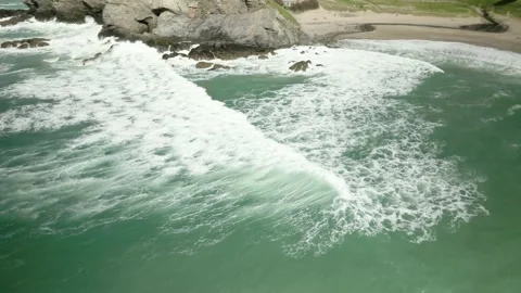 4k Aerial drone shot of waves crashing into UK beach cove in Cornwall Stock Footage 239094045