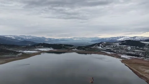 4K Aerial Drone Timelapse of Calm Lake, Snowy Mountains and Cloudy Horizon Stock Footage 341527733