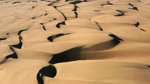 4K aerial drone view flying by beautiful wavy sand dunes in golden sunset light 스톡 동영상 134568340