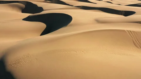 4K aerial drone view flying by dramatic wavy sand dunes in golden sunset light 스톡 동영상 134574166