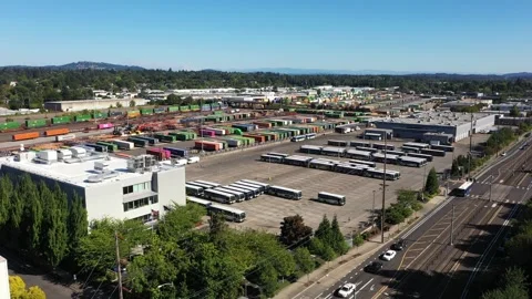 4K aerial drone view of freight train rail yard, public transit bus facility USA Stock Footage 345625320