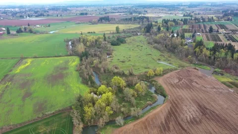 4K aerial drone view of a winding river flowing through farmland in Oregon, USA Stock Footage 332710652
