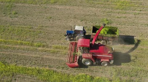 4K Aerial Elevated View Of Combine Harvester And Tractor Working Together In Fotos de archivo