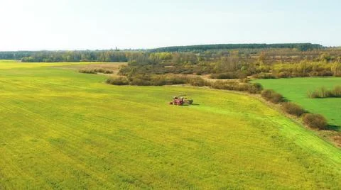 4K Aerial Elevated View Of Combine Harvester And Tractor Working Together In Fotos de archivo
