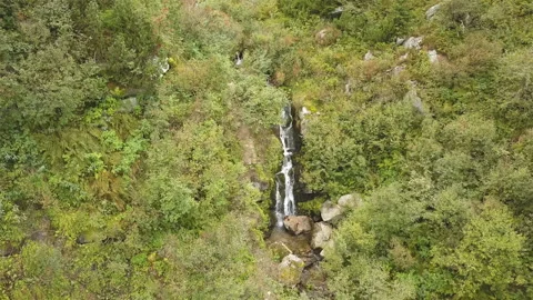 4K .Aerial. Flight down over small waterfalls in mountain hills. Stockbeeldmateriaal 119310371