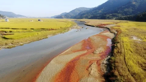 4k aerial fly over river in grassy valley near Pokhara in Nepal Stock Footage 107658633