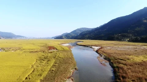 4k aerial fly over river in grassy valley near Pokhara in Nepal Stock Footage 107659905
