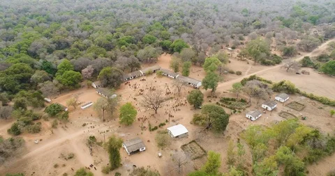 4K aerial fly over view of rural school with children playing on the dirt Stock Footage 102761447