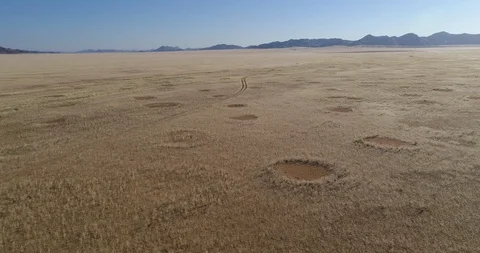 4K aerial fly over view of the famous fairy circles and a 4x4 vehicle track in Stock Footage 102765548