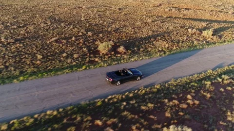 4k Aerial Flying Above White Convertible Car Driving Along America Highway Stock Footage 79595697
