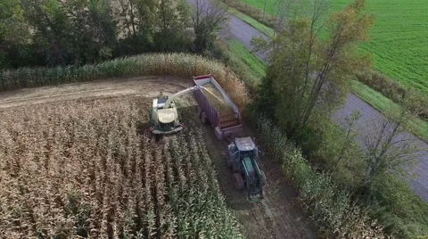 4k aerial flying backwards capturing farm tractor at work Stock Footage 55601500